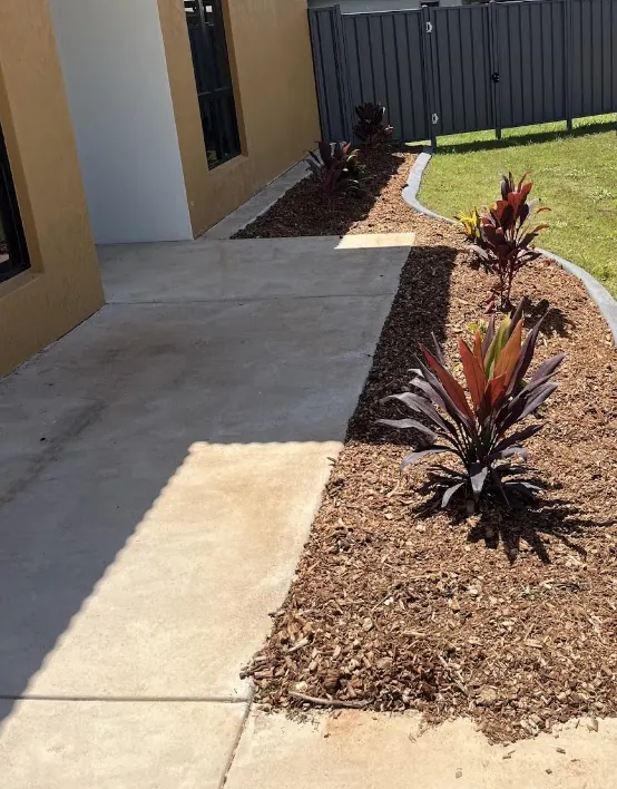 Freshly mulched curved garden beds with new plants in Harkaway